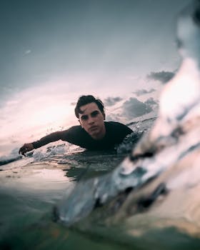A determined surfer navigates the ocean waves at sunset in Bali, Indonesia.